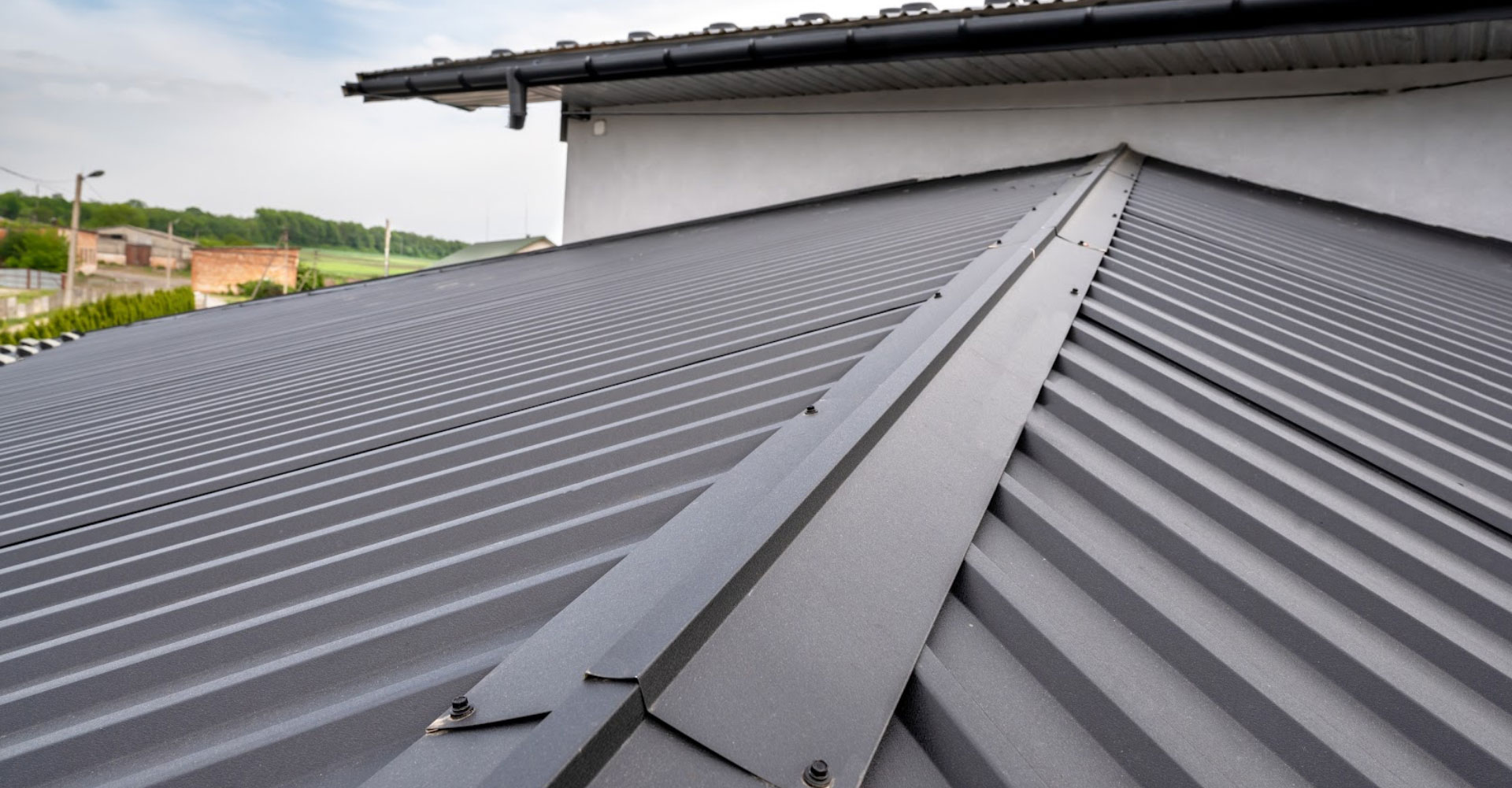 Dark standing seam metal roof panels running to the ridge on a commercial building in Haslet, TX