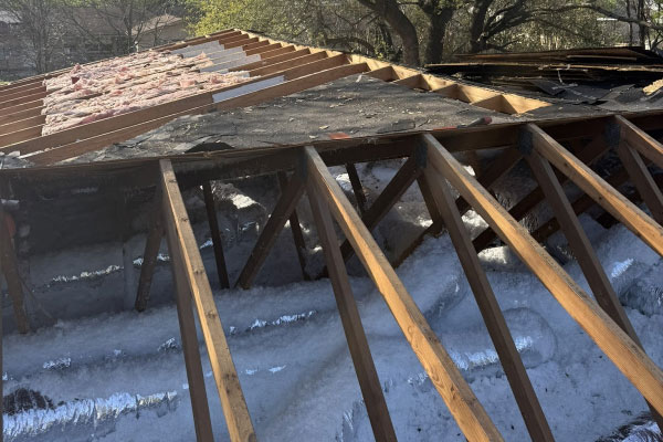 Open roof deck stripped to the rafters showing daylight through the framing in Haslet, TX