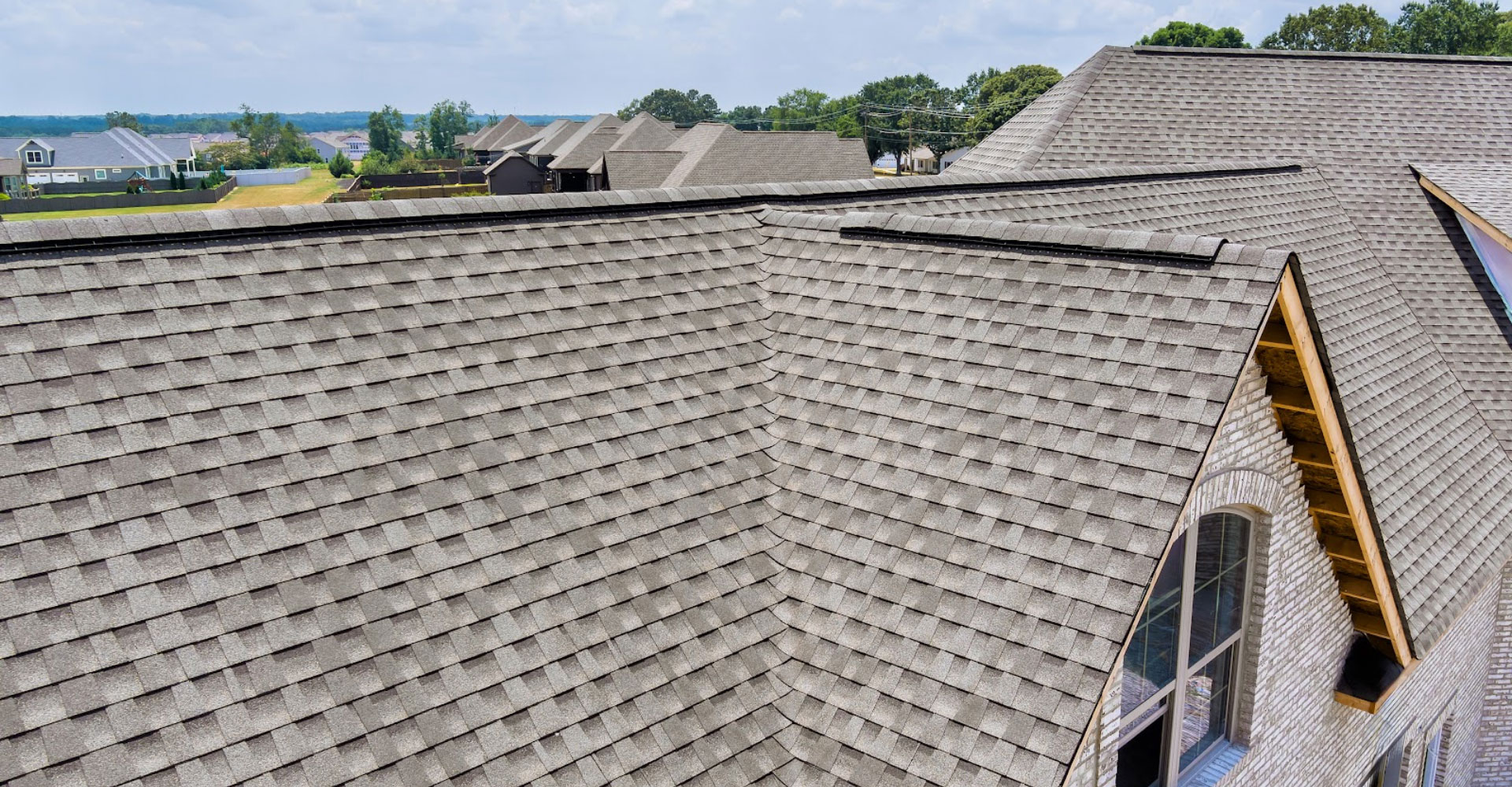 Long shingle roof run with a skylight and chimney under spring trees in Haslet, TX